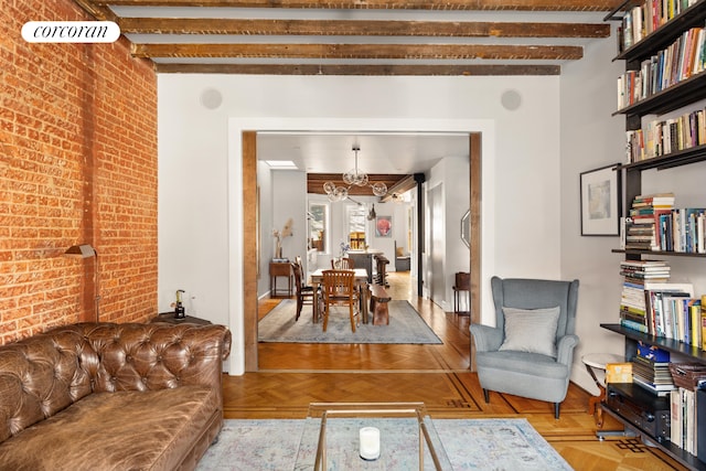 115 Milton St, New York City, NY 11222 - living room featuring an inviting chandelier, baseboards, brick wall, and beamed ceiling