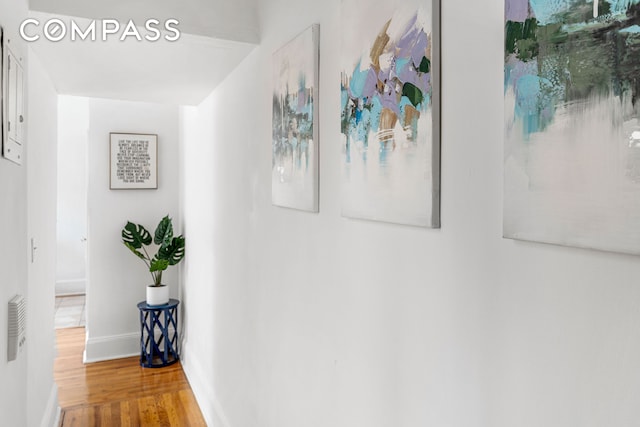 corridor featuring wood finished floors and baseboards