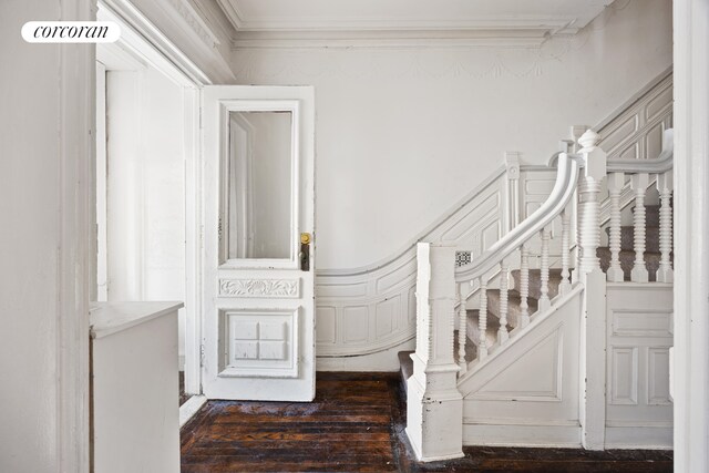 stairway featuring wood-type flooring and crown molding