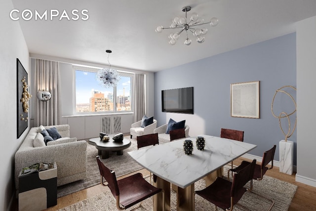 dining space with a notable chandelier, baseboards, and wood finished floors