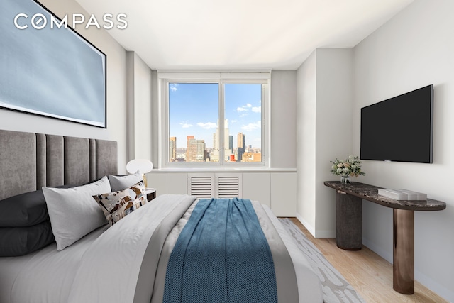 bedroom with wood finished floors and baseboards