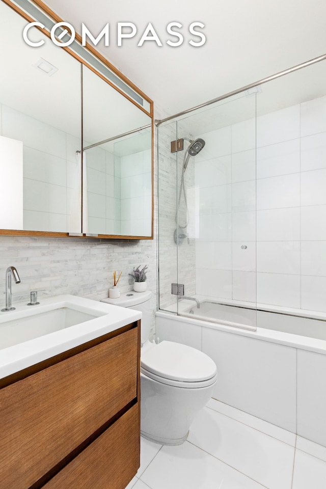 full bath featuring vanity, toilet, bath / shower combo with glass door, and tile patterned floors