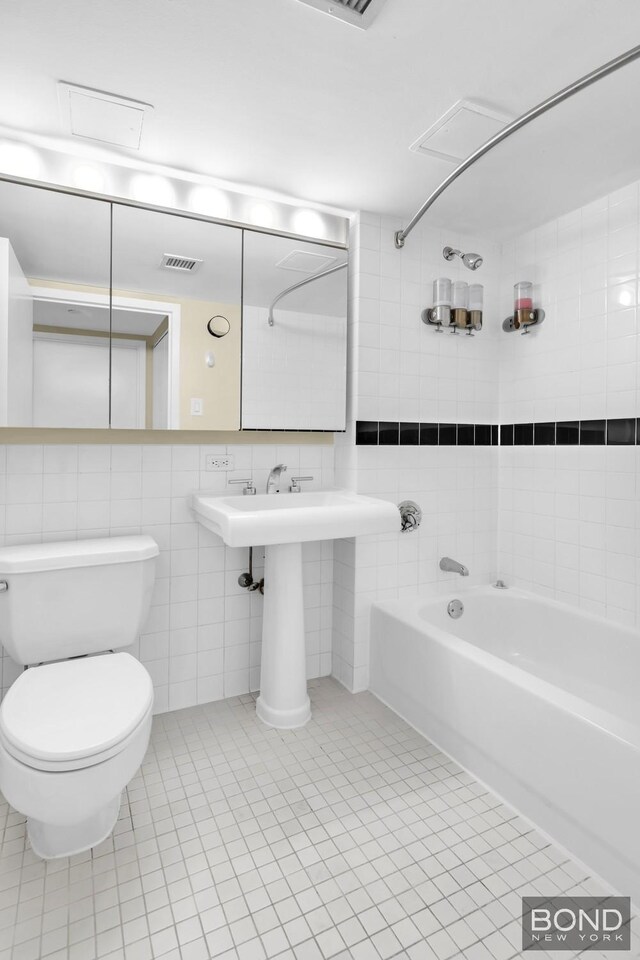 300 W 145th St Unit 1K, New York City, NY 10039 - bathroom featuring bathtub / shower combination, toilet, tile walls, and tile patterned floors