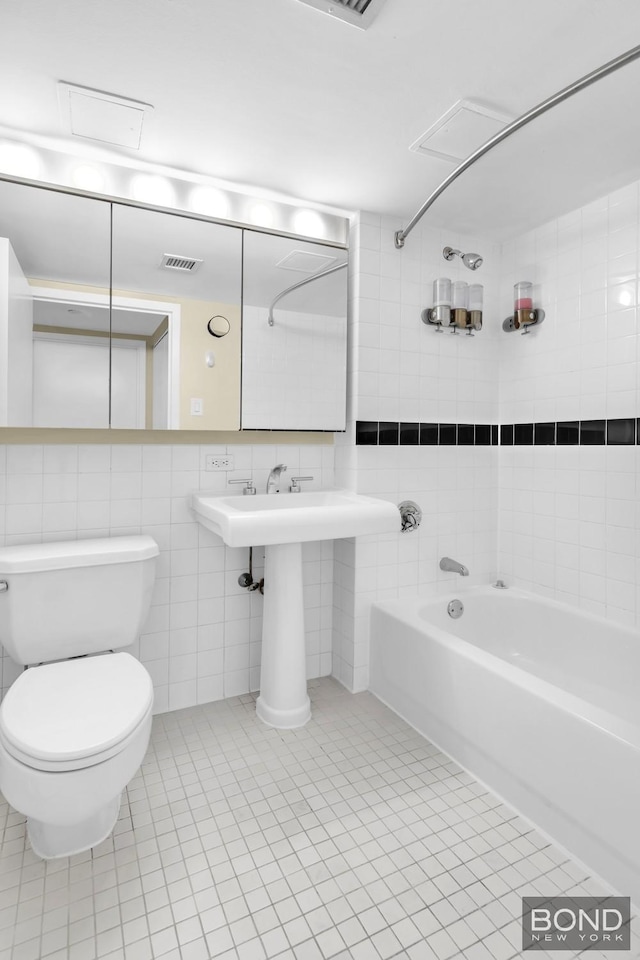 bathroom featuring visible vents, toilet, tile walls, shower / bathing tub combination, and tile patterned floors