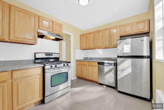 kitchen featuring light brown cabinets, under cabinet range hood, stainless steel appliances, a sink, and decorative backsplash