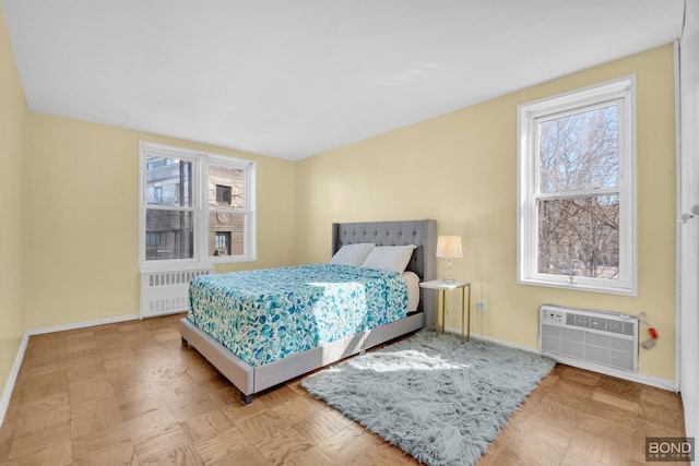 bedroom with baseboards, an AC wall unit, and radiator