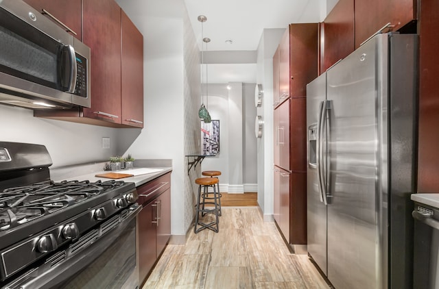 kitchen featuring dark brown cabinets, appliances with stainless steel finishes, and light countertops