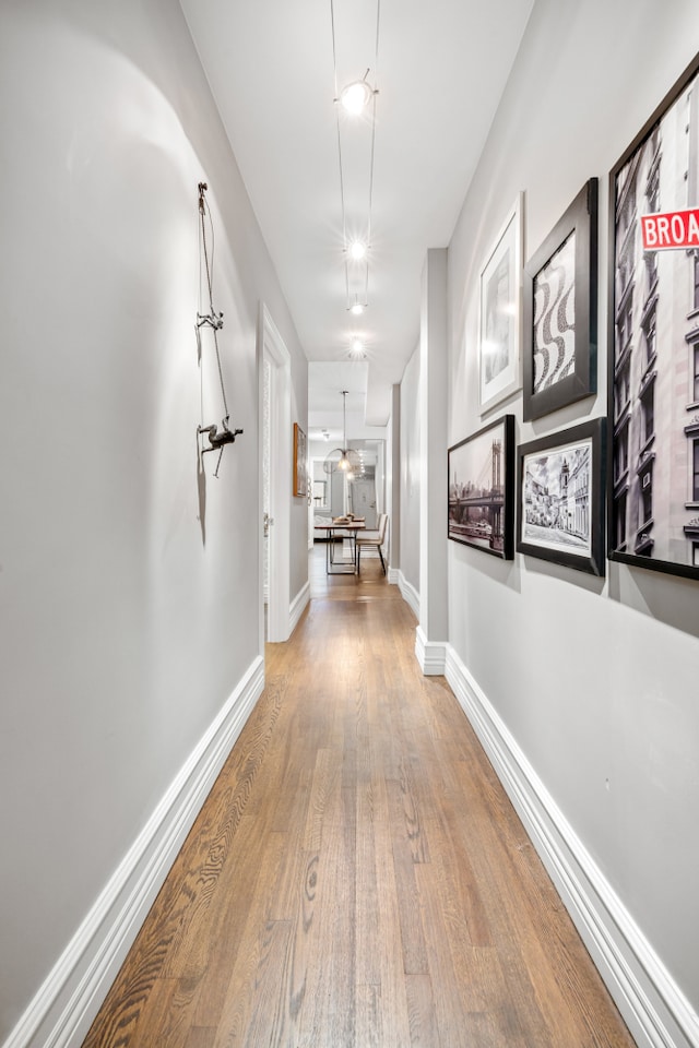 hall featuring wood finished floors and baseboards