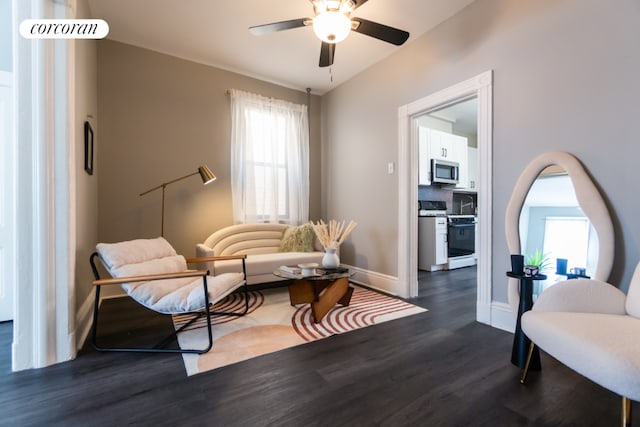 sitting room featuring dark wood-type flooring, ceiling fan, and a healthy amount of sunlight