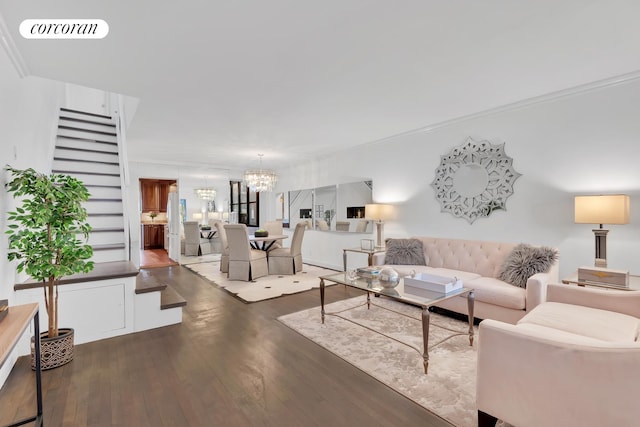 living area with ornamental molding, dark wood finished floors, visible vents, and a notable chandelier