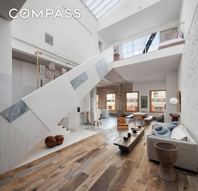 living room with hardwood / wood-style flooring, stairs, and a towering ceiling