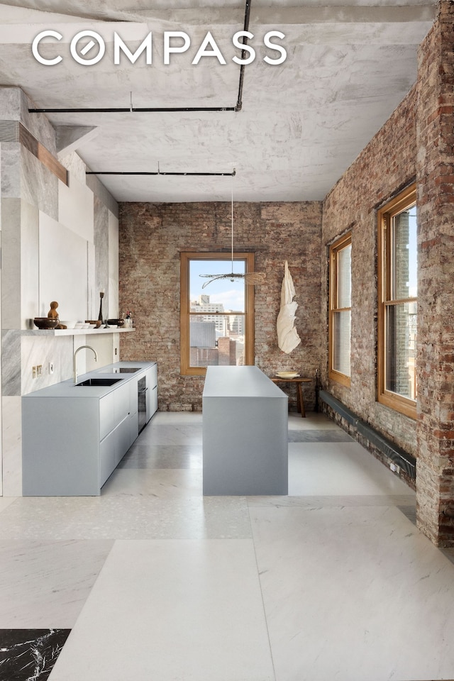 kitchen featuring a sink, hanging light fixtures, plenty of natural light, and light countertops