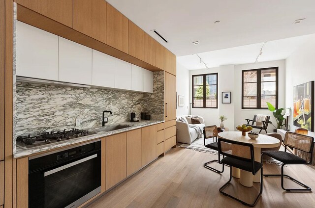 kitchen featuring stainless steel gas cooktop, visible vents, backsplash, wall oven, and extractor fan