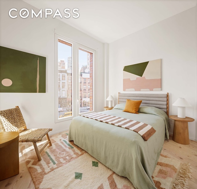 bedroom featuring a city view and wood finished floors