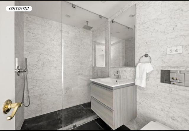 bathroom featuring tile walls, vanity, tile patterned flooring, and a tile shower