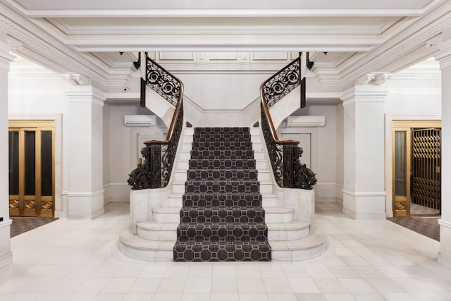 staircase featuring decorative columns, a wall unit AC, and ornamental molding