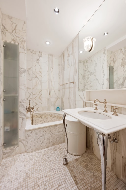 bathroom featuring a tub to relax in and tile walls