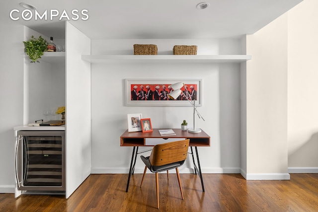 office area featuring dark wood-style floors, beverage cooler, and baseboards