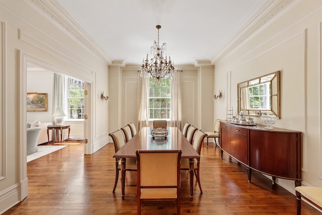 dining area with dark wood-style floors, a decorative wall, and crown molding