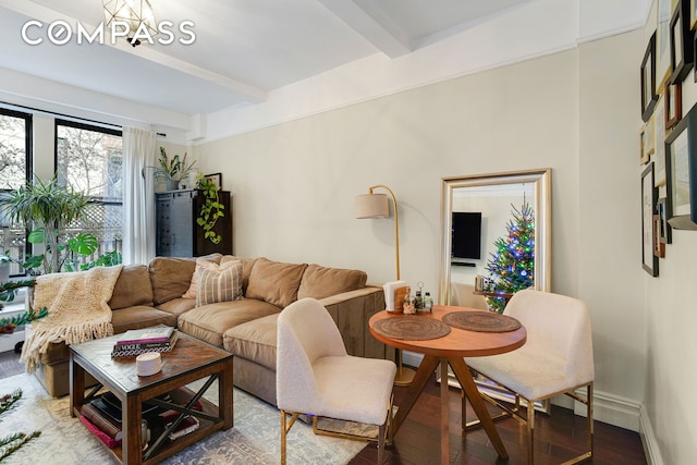 living room with beam ceiling, baseboards, and wood finished floors