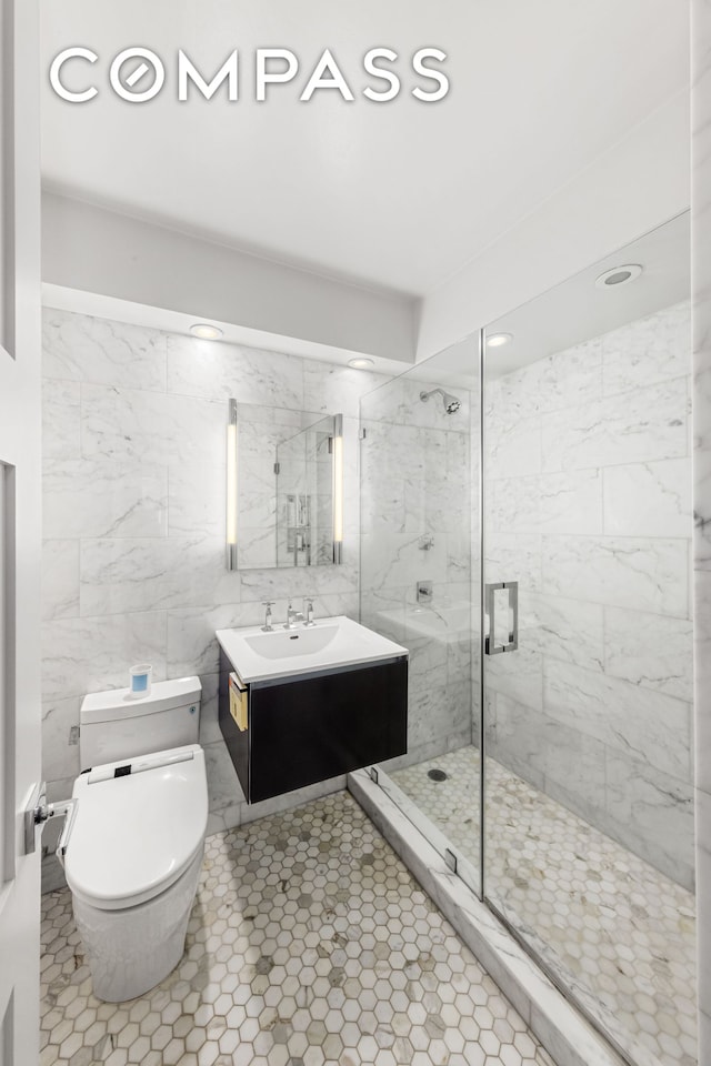 63 E 9th St Unit 14K, New York City, NY 10003 - full bath with a marble finish shower, vanity, toilet, tile patterned floors, and tile walls