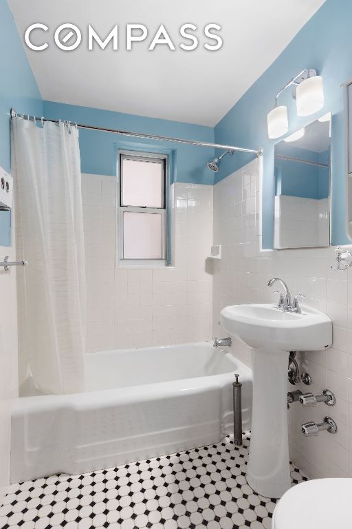 bathroom with tile walls, tile patterned flooring, toilet, and shower / bath combo