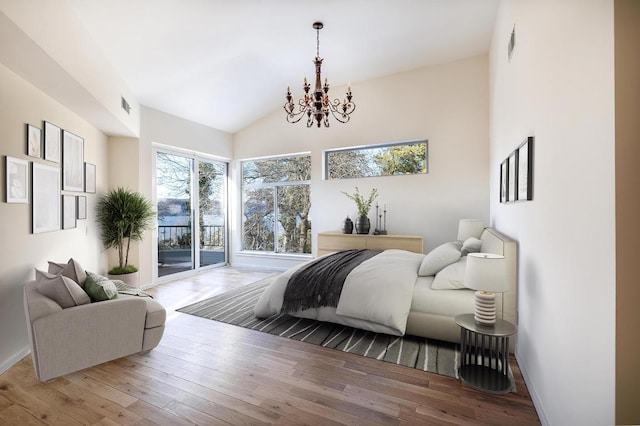 bedroom with access to exterior, a chandelier, wood-type flooring, and lofted ceiling