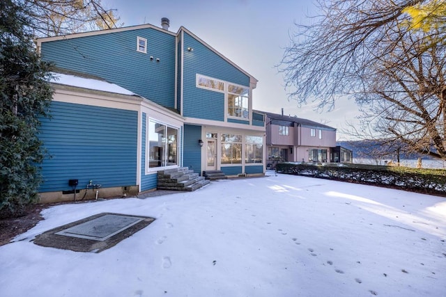 view of snow covered back of property