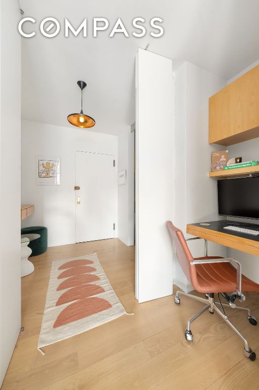 office space featuring light hardwood / wood-style floors and built in desk