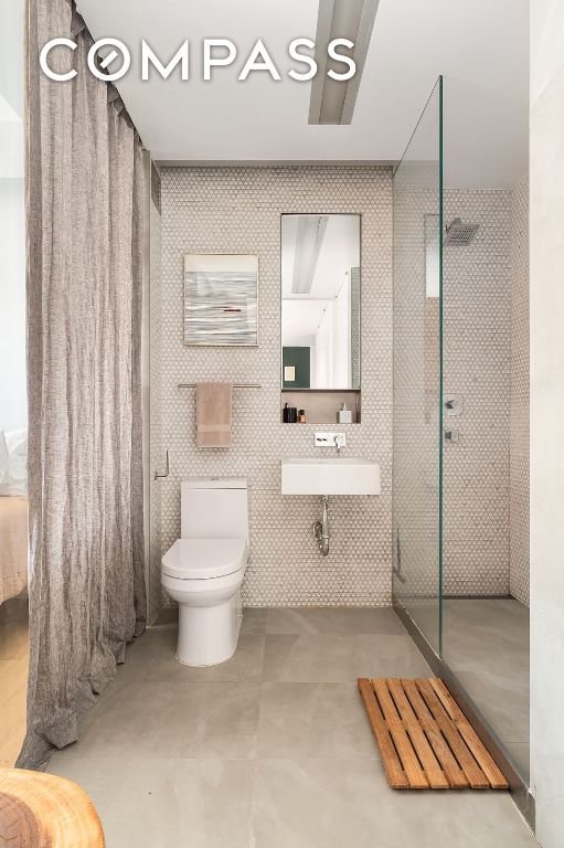 bathroom with sink, a shower, and toilet