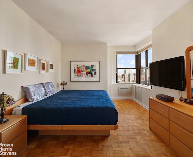 bedroom featuring an AC wall unit and baseboards