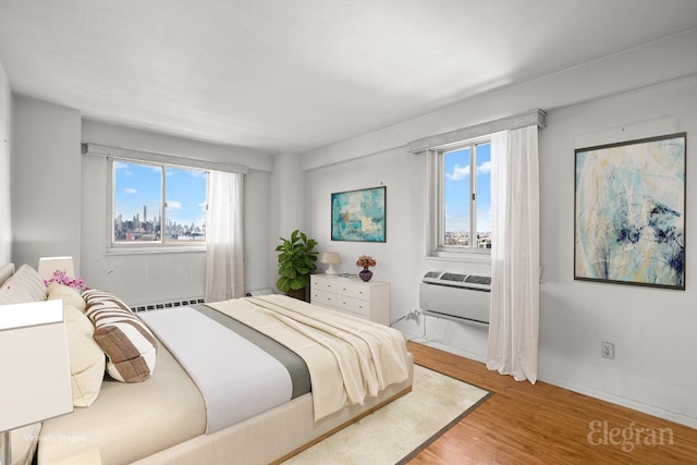 bedroom with hardwood / wood-style flooring and a wall mounted AC