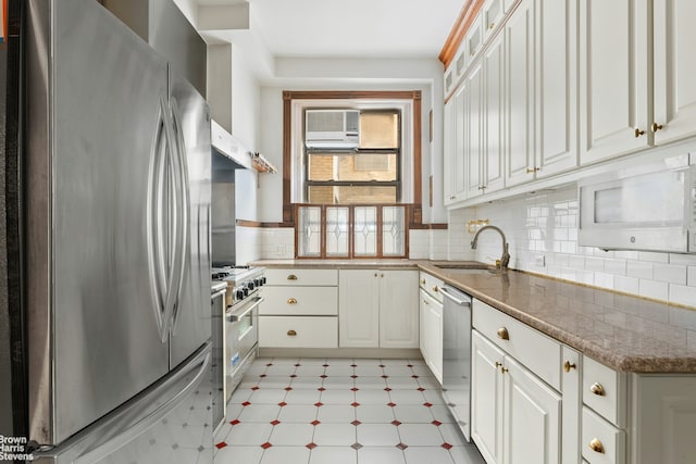 310 W 86th St Unit 3A, New York City, NY 10024 - kitchen with stainless steel appliances, light floors, a sink, white cabinetry, and backsplash