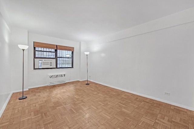 unfurnished room featuring light parquet flooring, cooling unit, and radiator heating unit