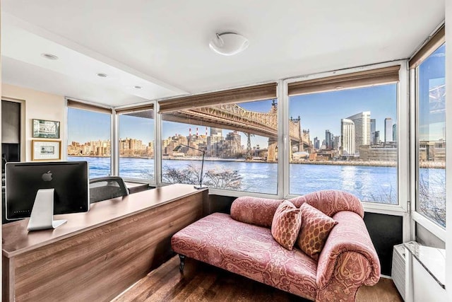 sunroom with a view of skyline and a water view