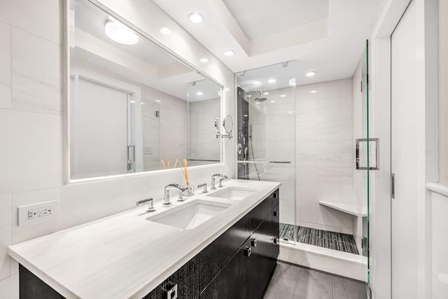 bathroom with a tray ceiling, vanity, and an enclosed shower