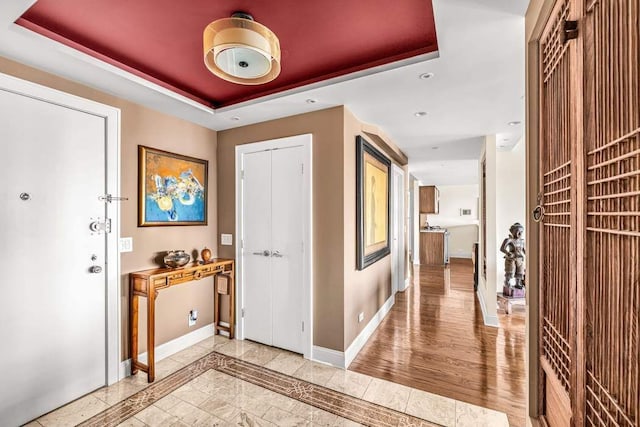 entrance foyer featuring a tray ceiling and hardwood / wood-style floors