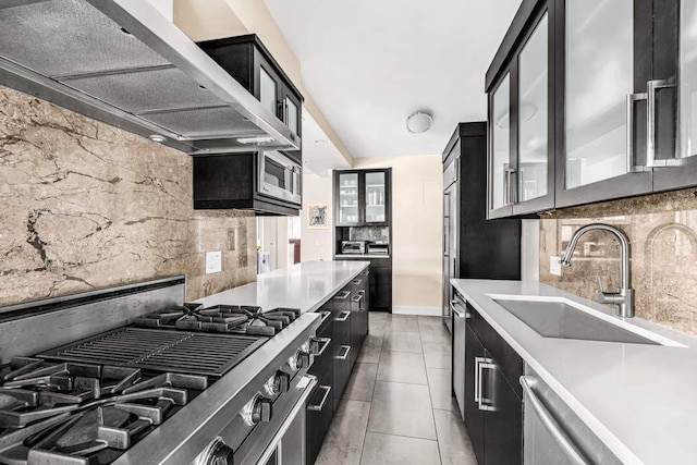 kitchen with sink, custom exhaust hood, tasteful backsplash, and tile patterned floors