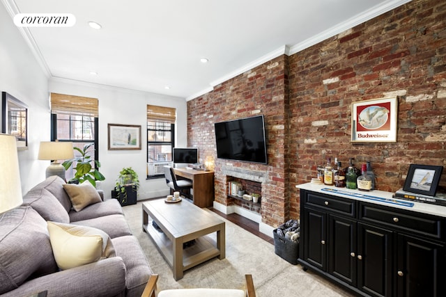 living room with brick wall, crown molding, and light hardwood / wood-style floors