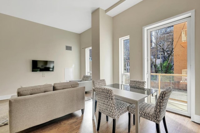 dining space with visible vents, baseboards, and wood finished floors