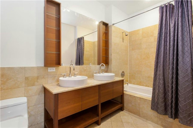 full bath featuring a sink, tiled shower / bath, toilet, and tile patterned floors