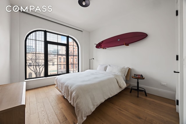 bedroom featuring hardwood / wood-style flooring and baseboards