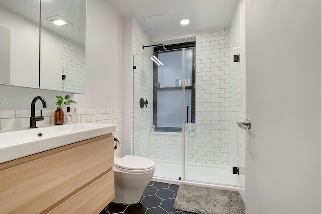 full bathroom featuring a stall shower, vanity, and toilet