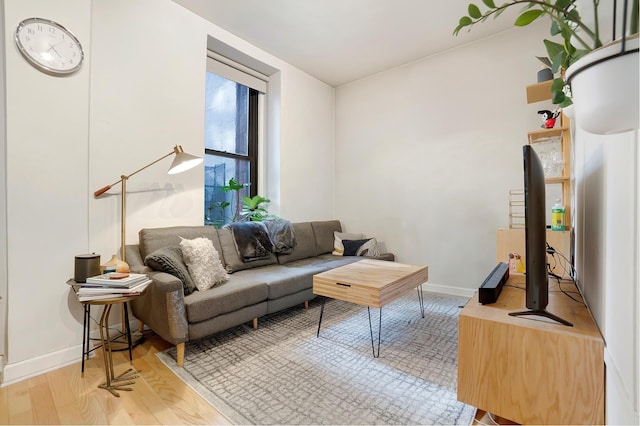 living area with baseboards and light wood finished floors