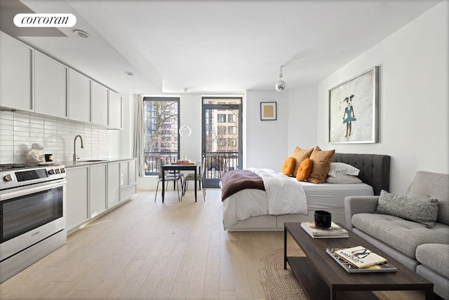 bedroom featuring sink and light hardwood / wood-style floors