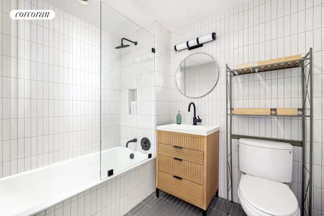 full bathroom with tile patterned floors, tile walls, toilet, and tiled shower / bath