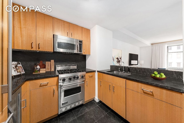 kitchen with sink, appliances with stainless steel finishes, dark stone counters, and decorative backsplash