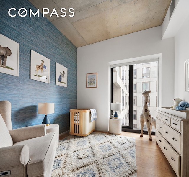 98 Front St Unit 8T, New York City, NY 11201 - sitting room with an accent wall, wood finished floors, baseboards, and wallpapered walls