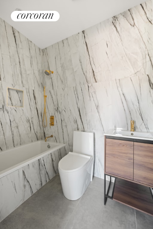 full bathroom featuring tiled shower / bath, toilet, concrete flooring, tile walls, and vanity