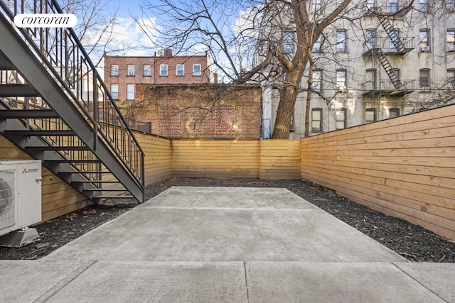 view of patio / terrace with stairs, fence, and ac unit